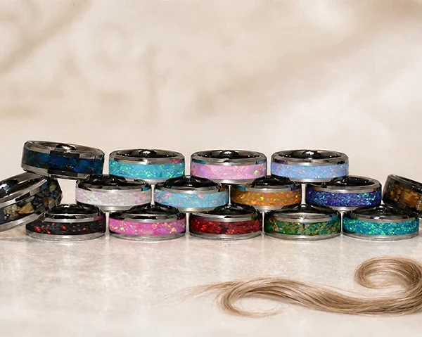 Collection de bagues souvenirs en tungstène argenté, aux opales de différentes couleurs, chacune avec un fin anneau de cheveux au centre.