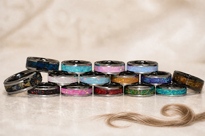 Collection de bagues souvenirs en tungstène argenté, aux opales de différentes couleurs, chacune avec un fin anneau de cheveux au centre.